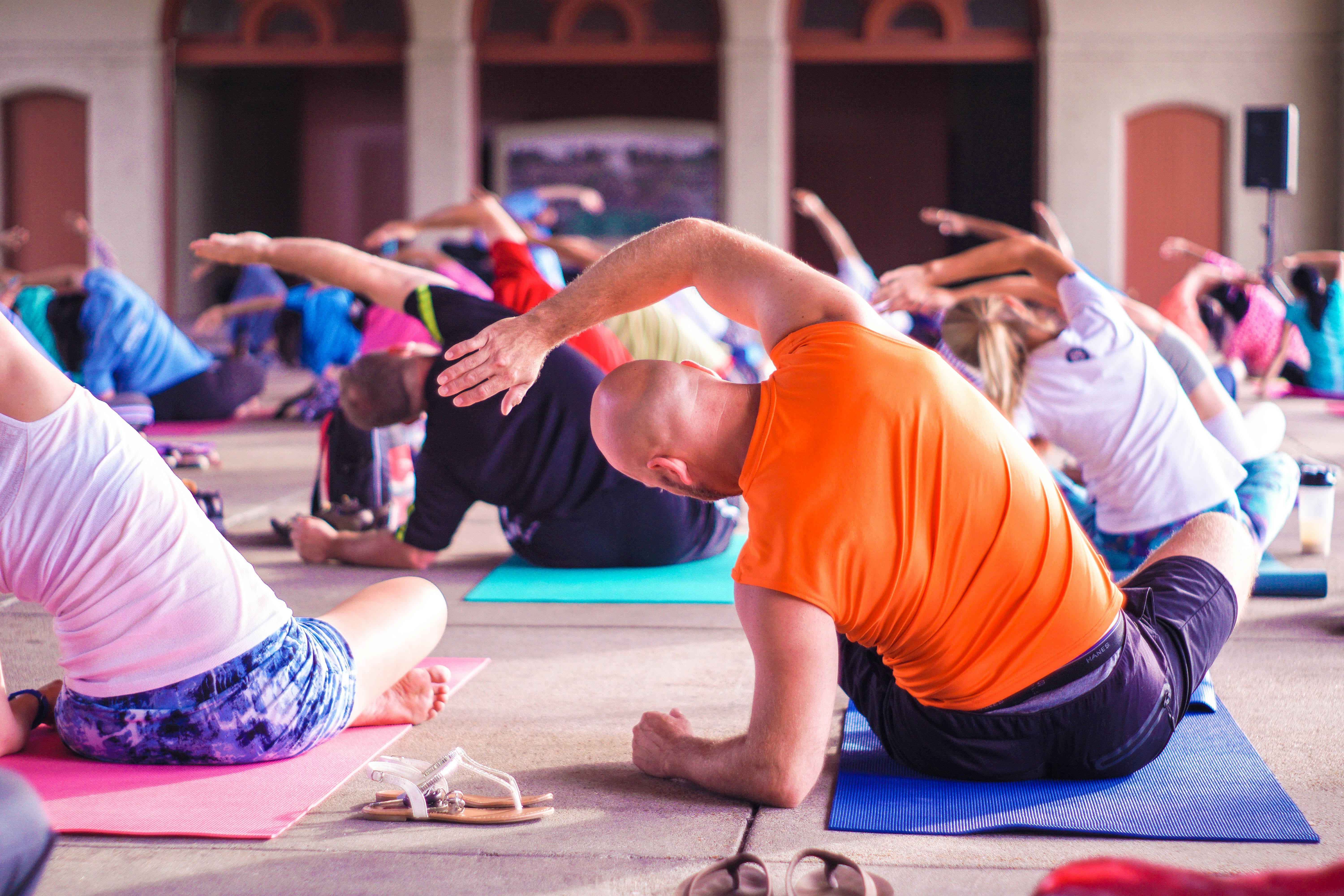 Group of people performing a yoga stretch in a class