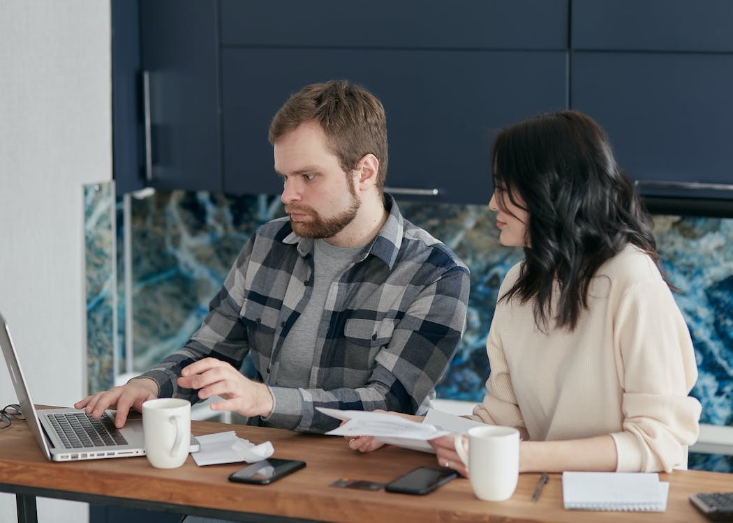 Man and woman looking at a laptop on their desk