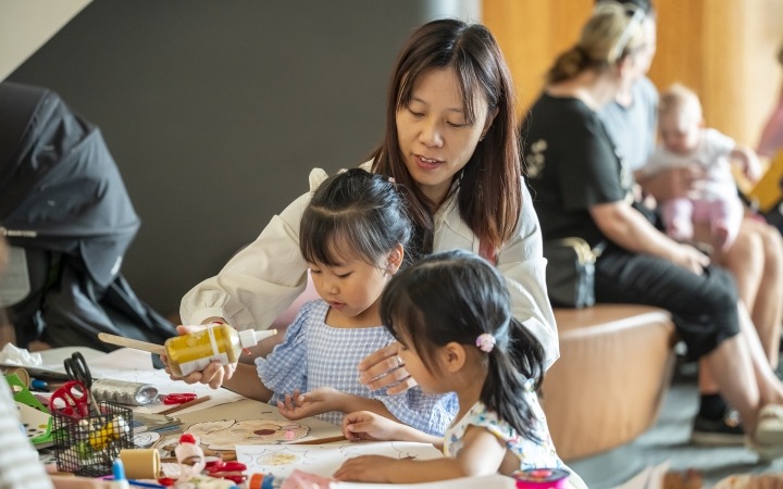 Woman with children doing artworks