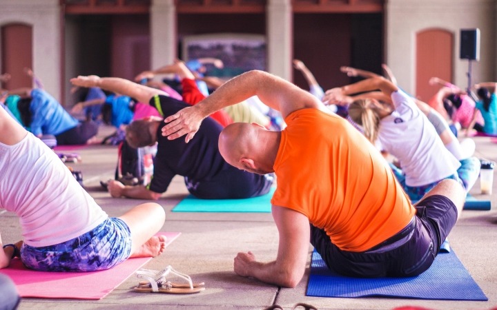 Group of people performing a yoga stretch in a class
