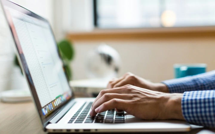 Photo of laptop with someone working on it