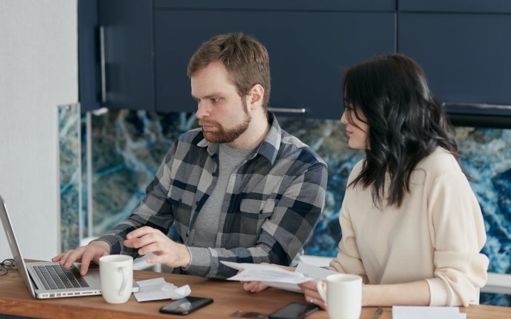 Man and woman looking at a laptop on their desk
